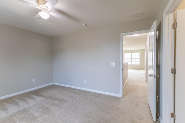 spare room featuring ceiling fan and light carpet