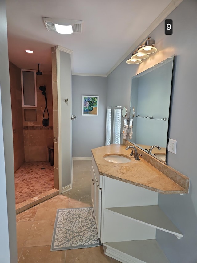 bathroom with vanity, tile patterned floors, ornamental molding, and tiled shower