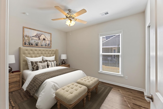 bedroom with wood finished floors, baseboards, ceiling fan, and visible vents