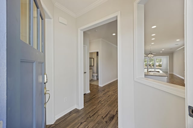 entryway with dark wood-type flooring, ornamental molding, baseboards, and recessed lighting