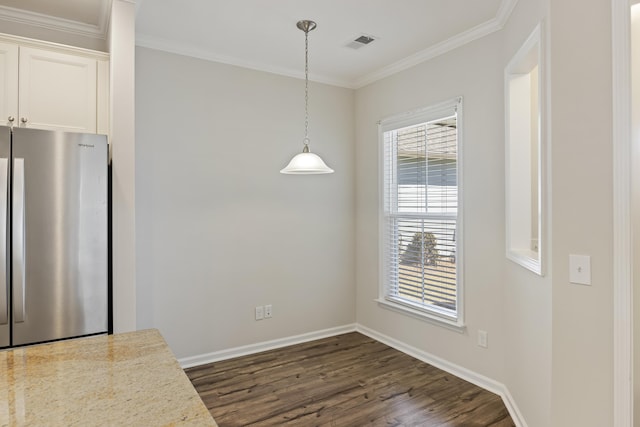 unfurnished dining area with baseboards, visible vents, crown molding, and dark wood finished floors