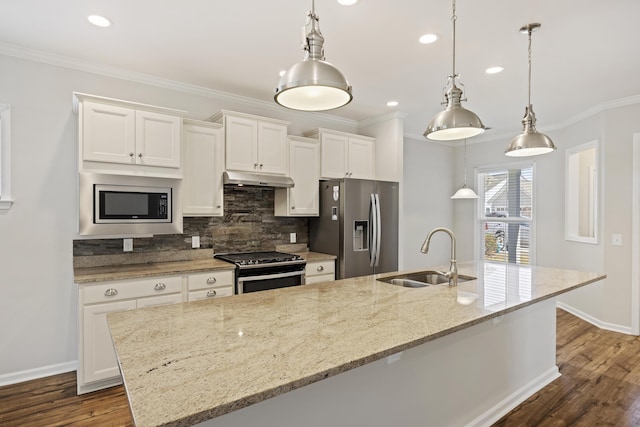 kitchen with under cabinet range hood, a center island with sink, a sink, white cabinets, and appliances with stainless steel finishes