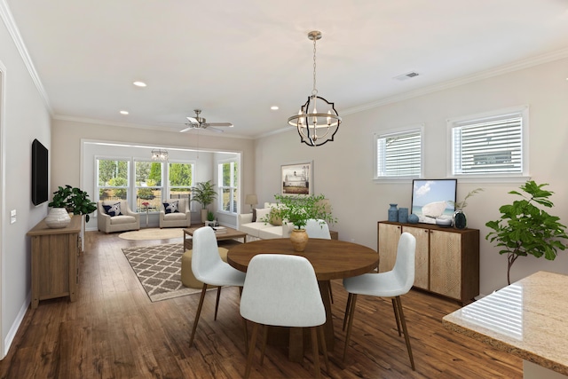 dining area featuring ornamental molding, dark wood-type flooring, a healthy amount of sunlight, and visible vents