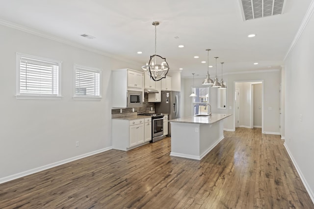 kitchen with white cabinets, visible vents, stainless steel appliances, and wood finished floors