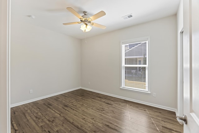 empty room featuring baseboards, visible vents, dark wood-type flooring, and a ceiling fan