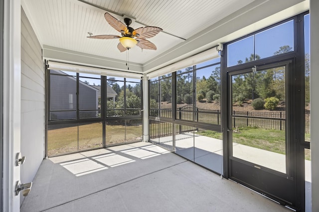 unfurnished sunroom with a ceiling fan
