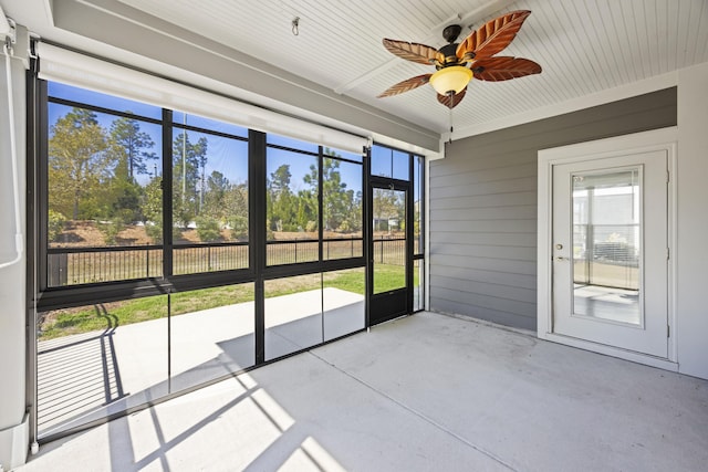 unfurnished sunroom featuring ceiling fan
