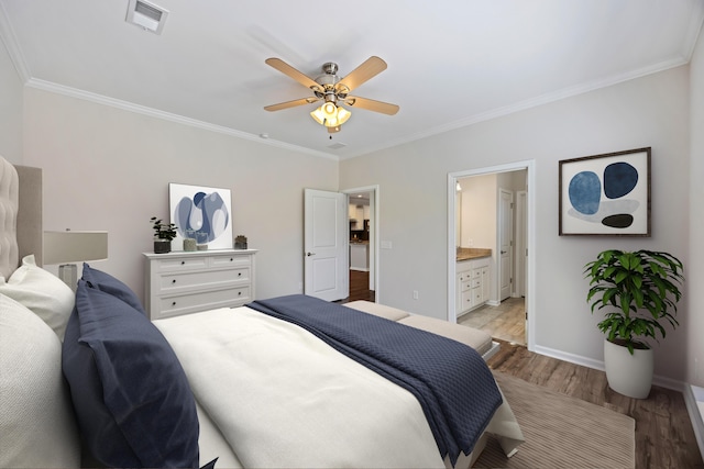 bedroom featuring baseboards, light wood-style flooring, visible vents, and crown molding