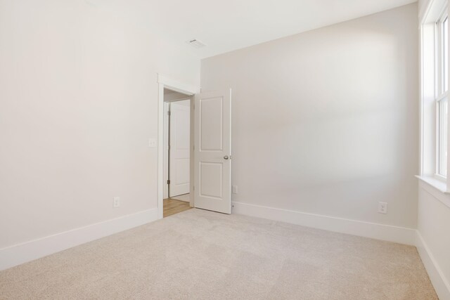 carpeted empty room featuring a wealth of natural light