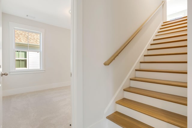 stairs featuring carpet flooring