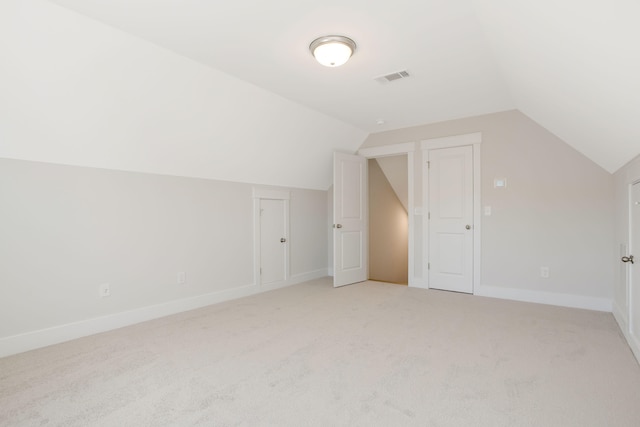 bonus room featuring lofted ceiling and light colored carpet