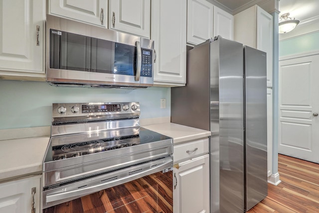 kitchen with stainless steel appliances, light countertops, white cabinets, and light wood-type flooring