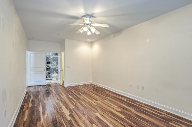 empty room featuring ceiling fan, dark wood-style flooring, and baseboards