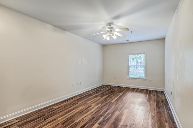 empty room featuring dark wood-type flooring, baseboards, and ceiling fan