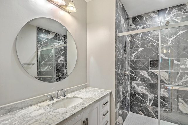 full bath with a marble finish shower and vanity