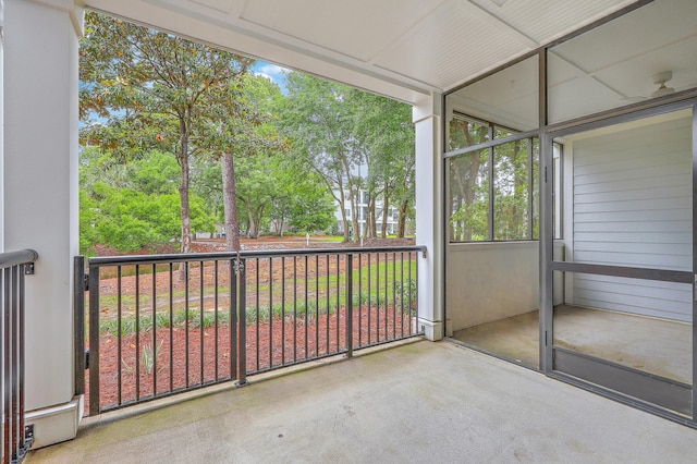 unfurnished sunroom with view of wooded area
