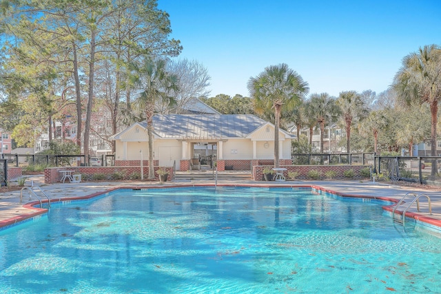 community pool featuring fence and a patio