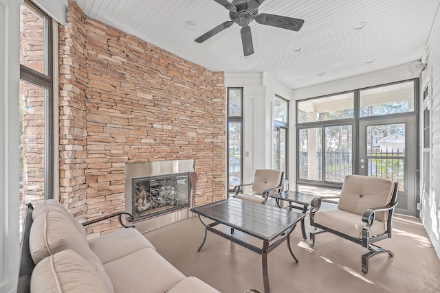 living area with a fireplace and a ceiling fan