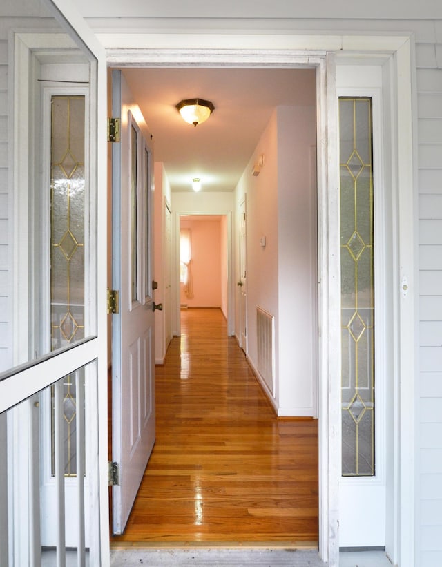 corridor featuring light wood-style floors and visible vents