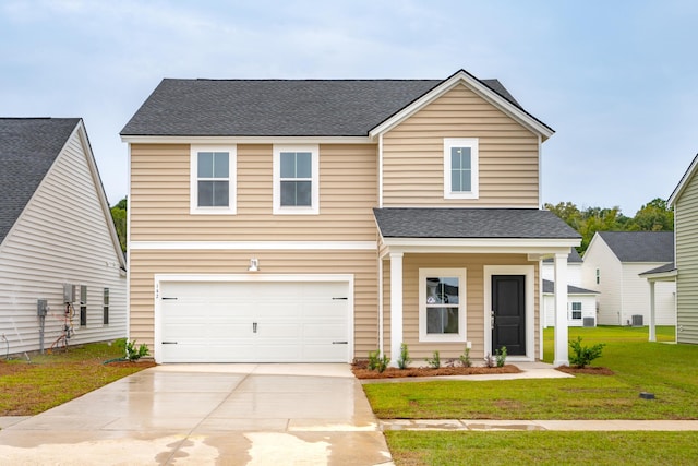 traditional home featuring driveway, an attached garage, a front lawn, and roof with shingles