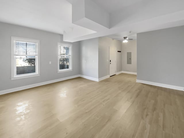 spare room with ceiling fan, light hardwood / wood-style floors, and electric panel