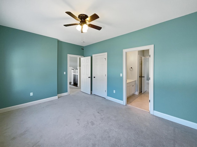 unfurnished bedroom featuring light colored carpet, ceiling fan, and ensuite bathroom