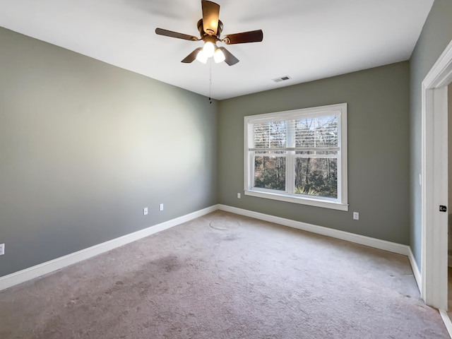 carpeted spare room with ceiling fan