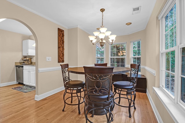 dining area with a chandelier, light hardwood / wood-style floors, and ornamental molding