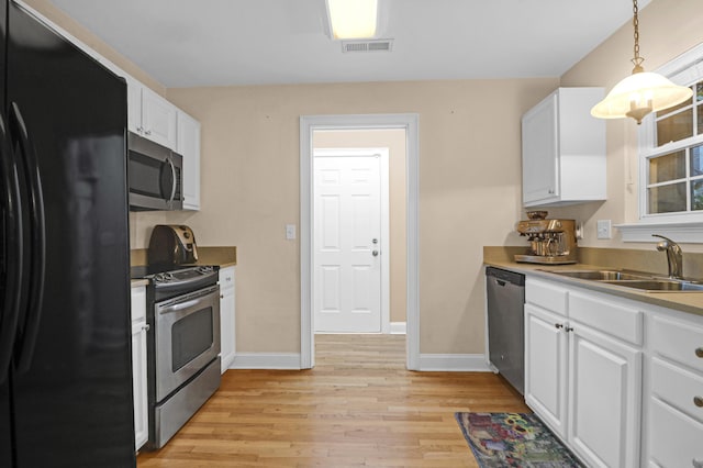 kitchen featuring hanging light fixtures, white cabinetry, sink, and appliances with stainless steel finishes