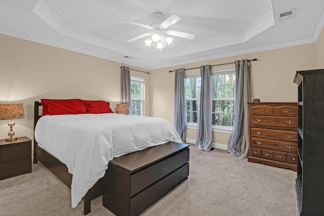 carpeted bedroom with a raised ceiling, ceiling fan, and ornamental molding