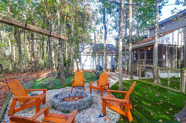 view of patio with a sunroom and an outdoor fire pit