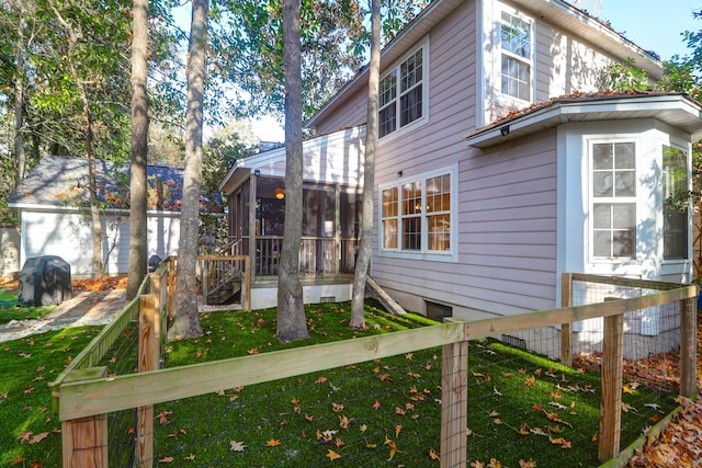 rear view of house with a sunroom and a yard