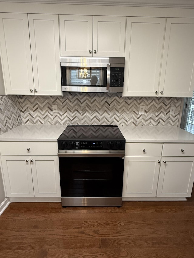 kitchen with white cabinetry, backsplash, electric range, and dark hardwood / wood-style flooring