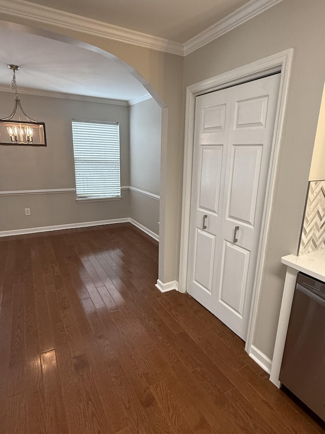 interior space featuring ornamental molding, an inviting chandelier, and dark hardwood / wood-style flooring