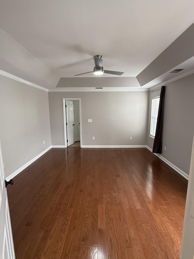 spare room featuring ornamental molding, dark hardwood / wood-style floors, ceiling fan, and a tray ceiling