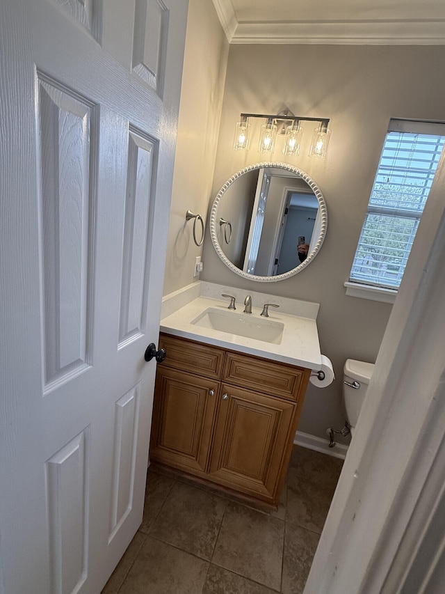 bathroom featuring tile patterned flooring, crown molding, vanity, and toilet