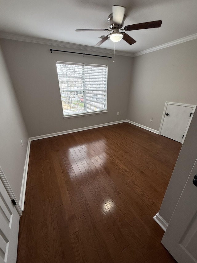 unfurnished room featuring dark wood-type flooring, ceiling fan, and crown molding