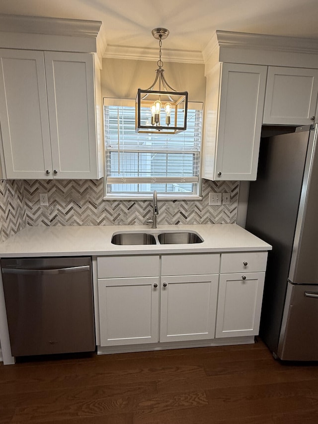 kitchen with stainless steel appliances, white cabinetry, hanging light fixtures, and sink