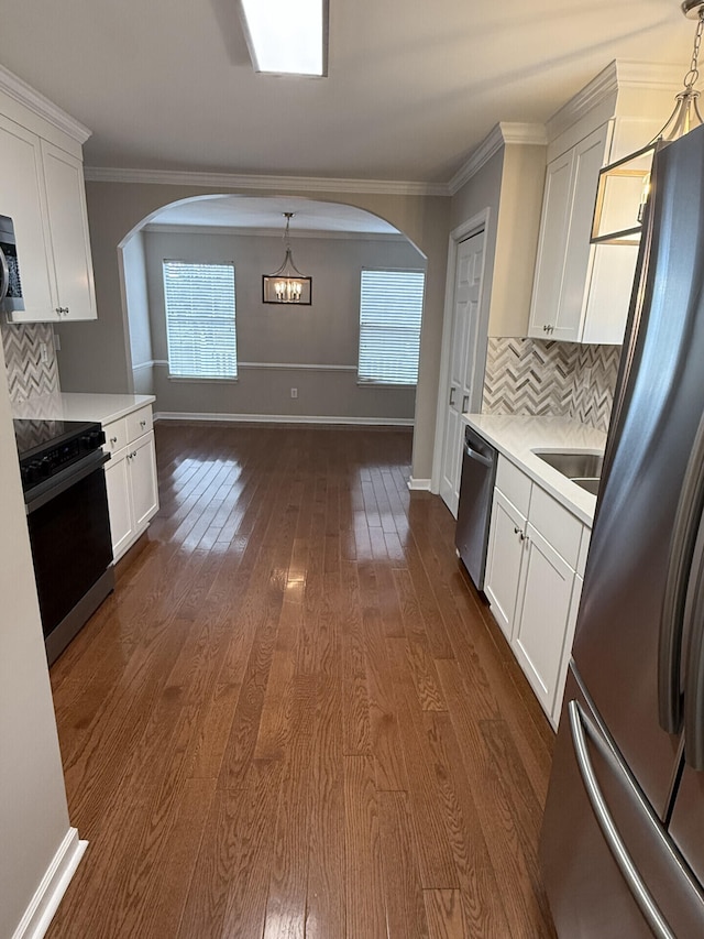 kitchen featuring hanging light fixtures, stainless steel appliances, dark hardwood / wood-style floors, and white cabinets