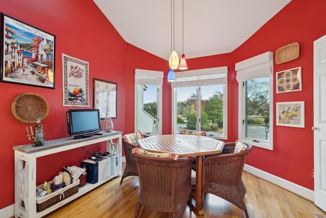 dining space featuring vaulted ceiling and hardwood / wood-style flooring