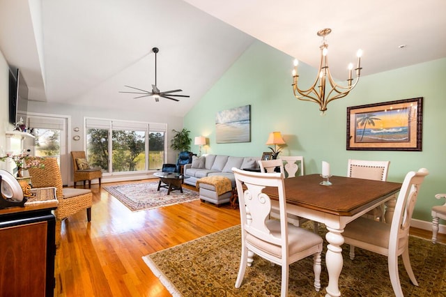 dining room featuring hardwood / wood-style floors, high vaulted ceiling, and ceiling fan with notable chandelier