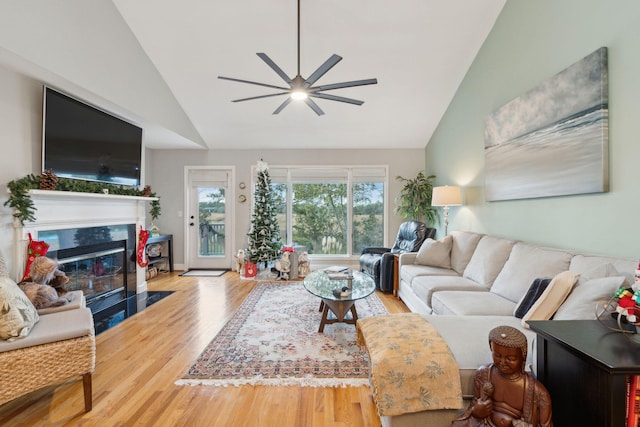 living room with hardwood / wood-style floors, high vaulted ceiling, and ceiling fan