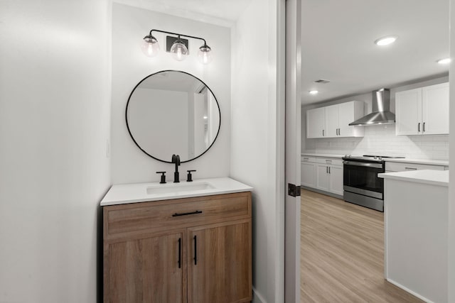 bathroom featuring wood-type flooring, sink, and tasteful backsplash