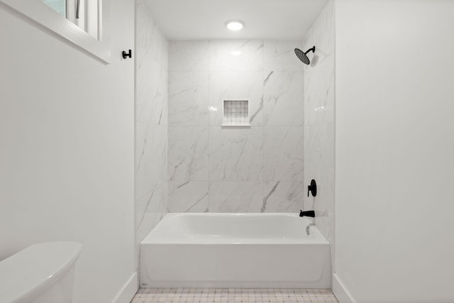 bathroom with tiled shower / bath combo and toilet