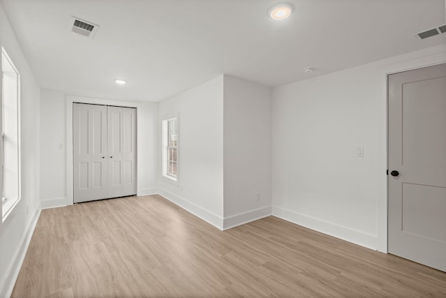 spare room with light hardwood / wood-style flooring and plenty of natural light