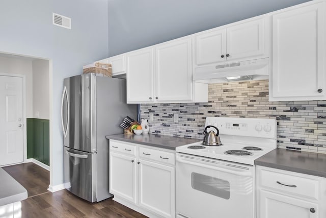 kitchen with dark countertops, under cabinet range hood, electric range, and freestanding refrigerator