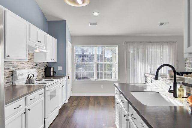 kitchen with visible vents, white electric range, under cabinet range hood, white cabinetry, and a sink