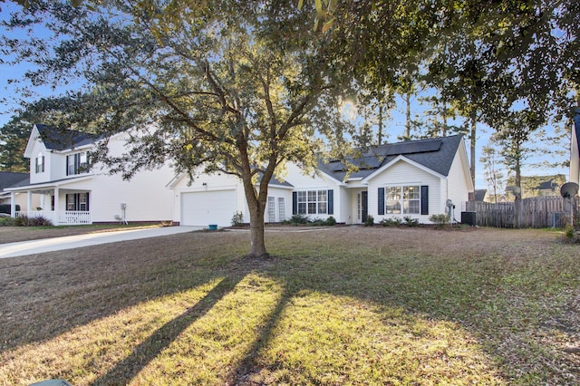 view of front of home with cooling unit, fence, driveway, and a front lawn