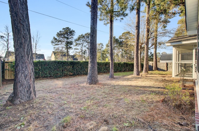 view of yard featuring a sunroom and a fenced backyard