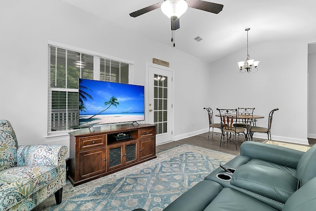 living room featuring wood-type flooring, ceiling fan with notable chandelier, and lofted ceiling